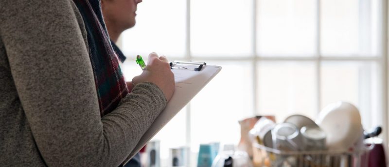 Person writing on a clipboard.