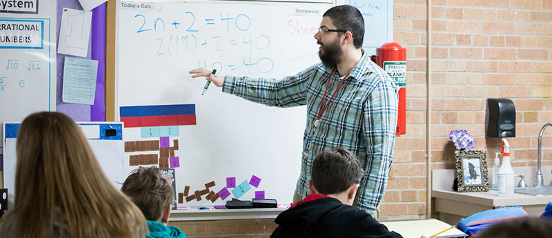 Teacher teaches math class in elementary school classroom