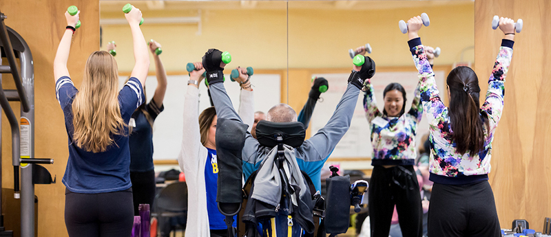 Participants in adaptive fitness class lift weights